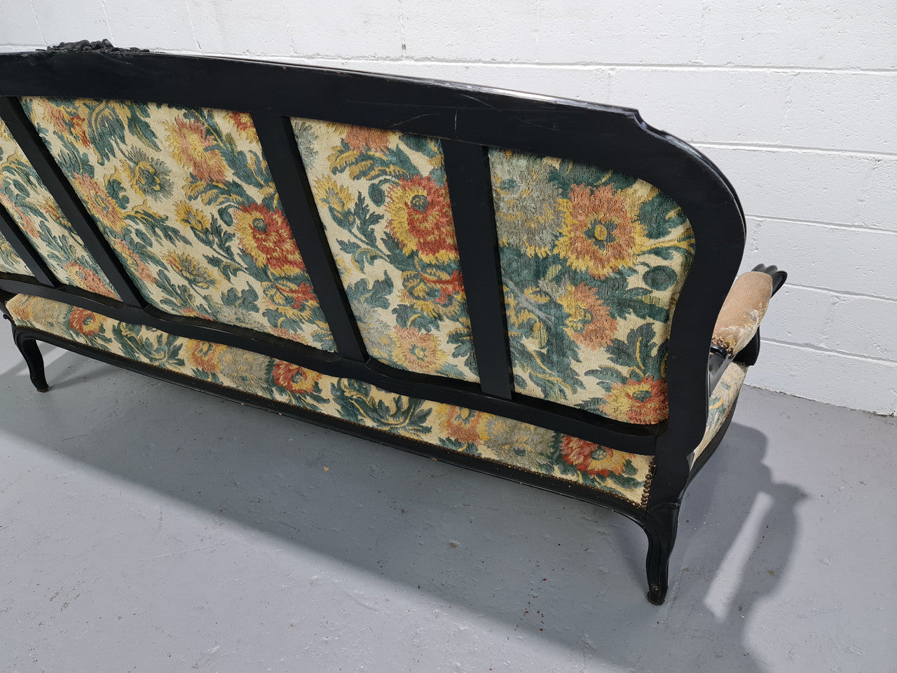 A Substantial Antique 19th Century Louis XV style ebonized serpentine front settee. The fabric is in used condition showing use and could be used as is or reupholster.