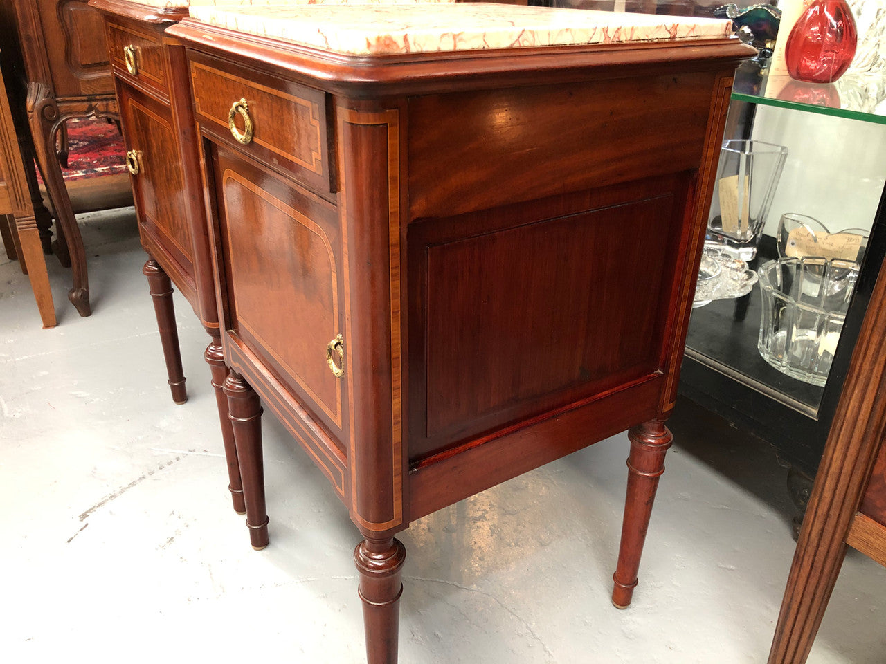 A lovely French inlaid pair of flame mahogany bedside cabinets with ormolu and in good condition.