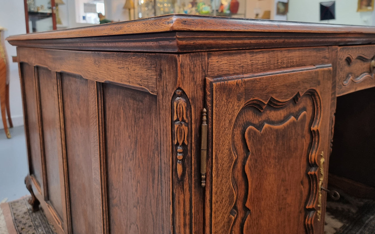 Fabulous Louis XV style French Oak beautifully carved full partners desk. Both sides have a functioning drawer in the middle and two cupboards either side. On both sides one cupboard door opens up to four smaller internal drawers. Plenty of storage space and a large top surface to work on. It is in good original detailed condition.