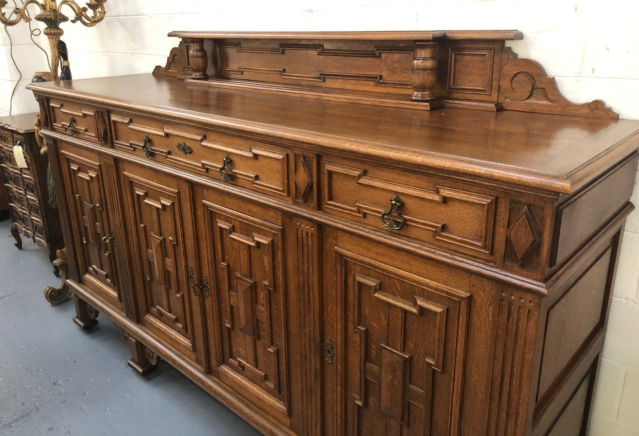 Beautiful carved French Oak four-door buffet with three drawers and lots of room for storage in good original detailed condition.