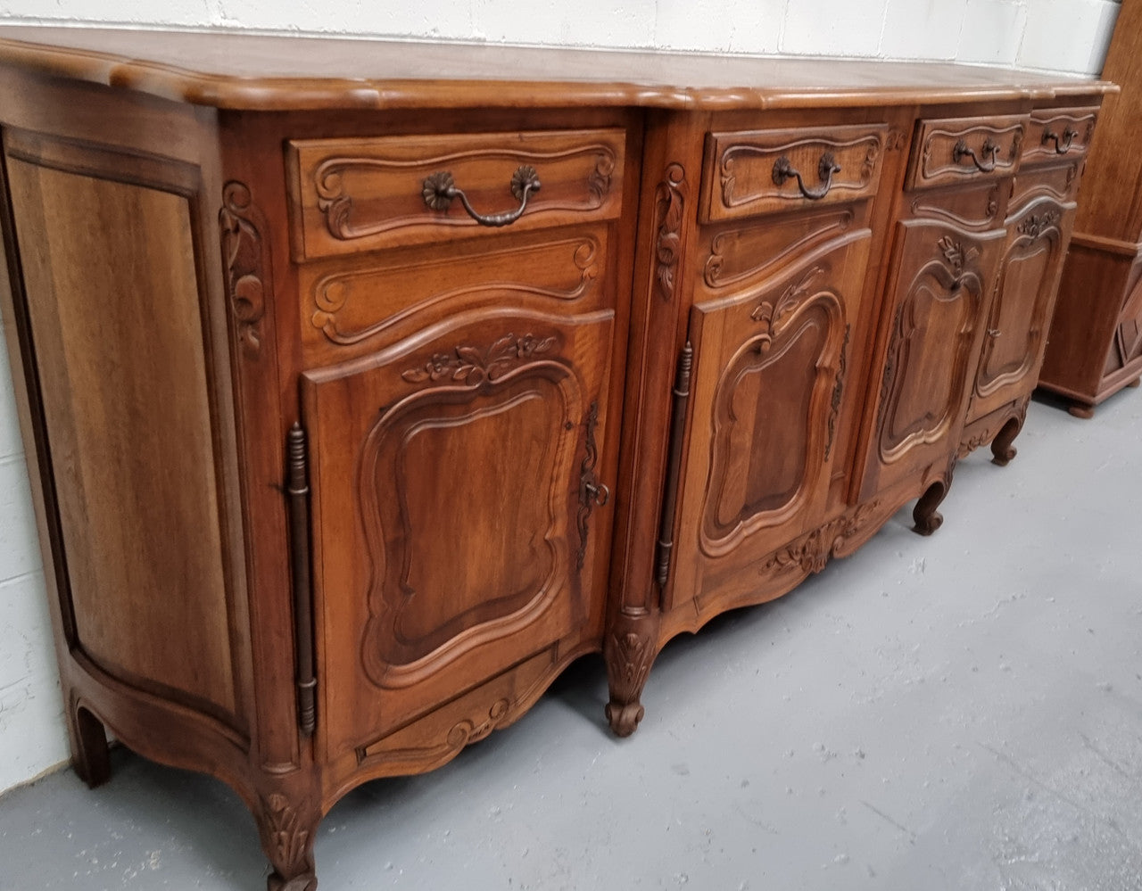 A Beautifully carved French Walnut Louis XV style four door sideboard. Plenty of storage space with four doors as well as four drawers. It is in good original detailed condition.