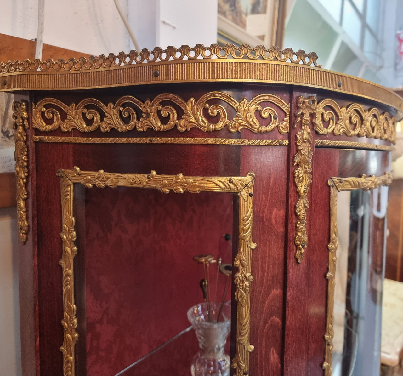 French Mahogany two shelf vitrine with curved glass and brass mounts. It has a lovely frabic interior and two glass shelves. In good original detailed condition.