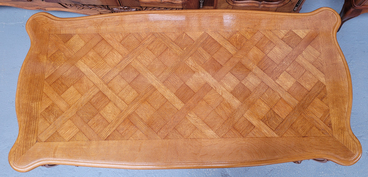 French Oak parquetry top coffee table with decorative carved base. It is in good original detailed condition.