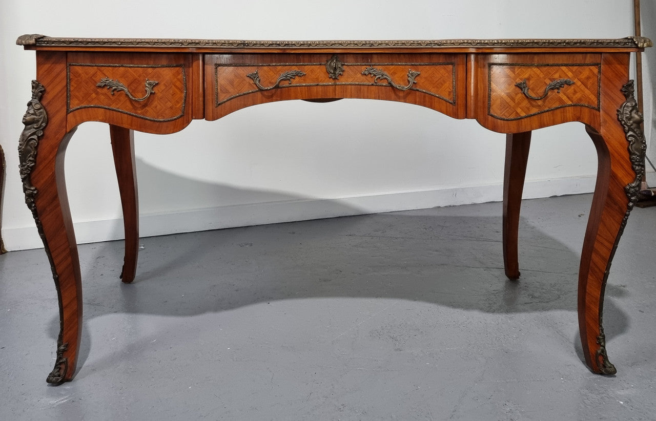 An impressive French kingwood and ormolu mounted bureau plat. It has a brown tooled leather writing surface, three decorated frieze drawers to the shaped apron with foliate swing handles and well cast figural mounts. Beautiful cabriole legs with decorative ormolu mounts and trims throughout. In good original detailed condition.