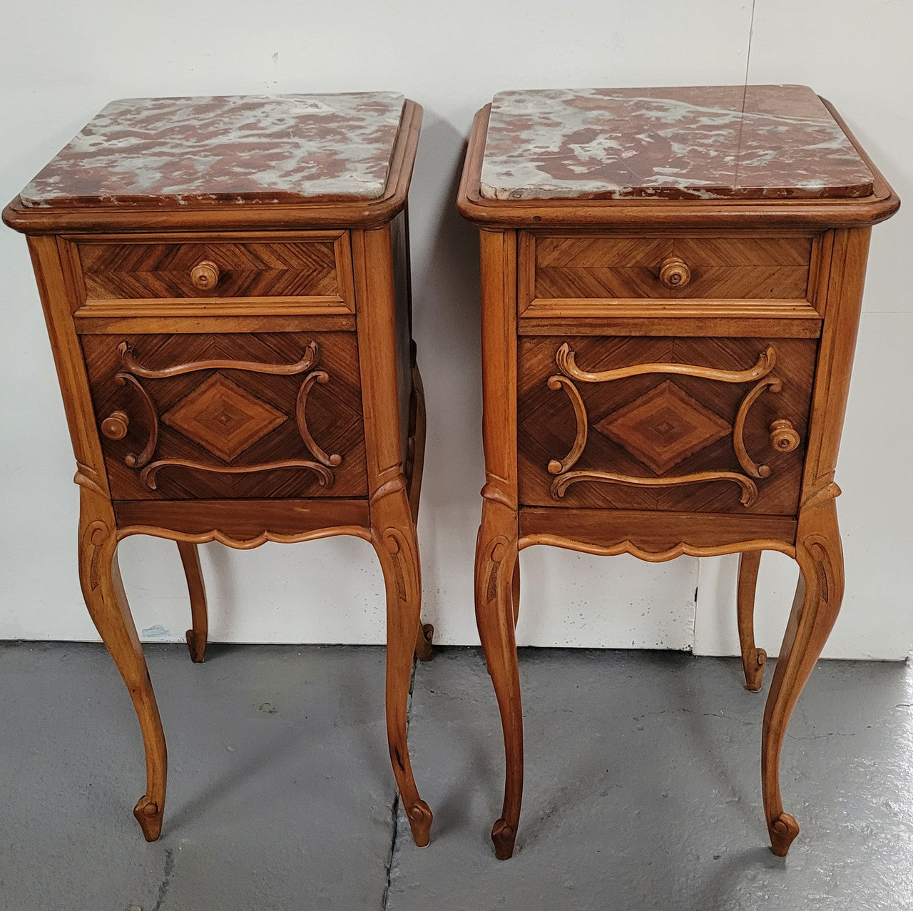 Pair French Walnut Louis XV style Bedside Cabinets with inset rouge carrera marble tops and parquetry inlay. Consisting of one drawer and one cupboard on very elegant legs. Circa: 1900's.