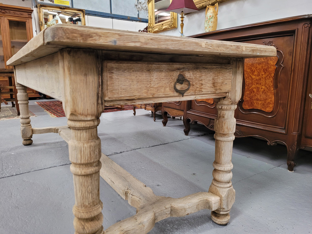 French stripped Oak pedestal stretcher base Farmhouse table with two drawers on either side of table. Features raw wood that could be used as is for a distressed look, or finished and waxed for a more refined look.