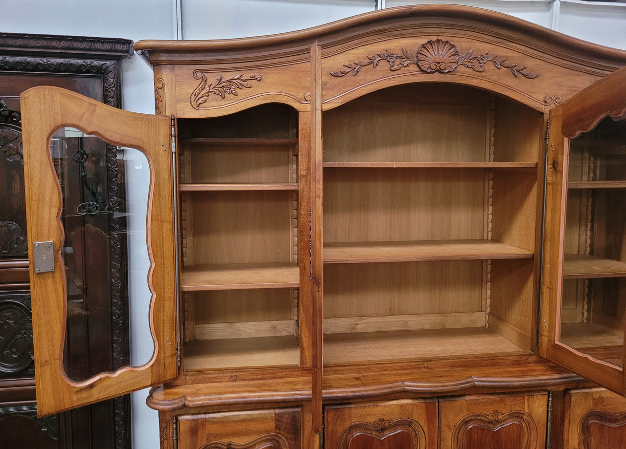 Magnificent French Walnut two-body four door display cabinet. Heaps of storage space with four glass doors at the top with shelves and four solid doors below also with shelving. It has been sourced from France and comes with a key for each door and all are lockable. In good original detailed condition.