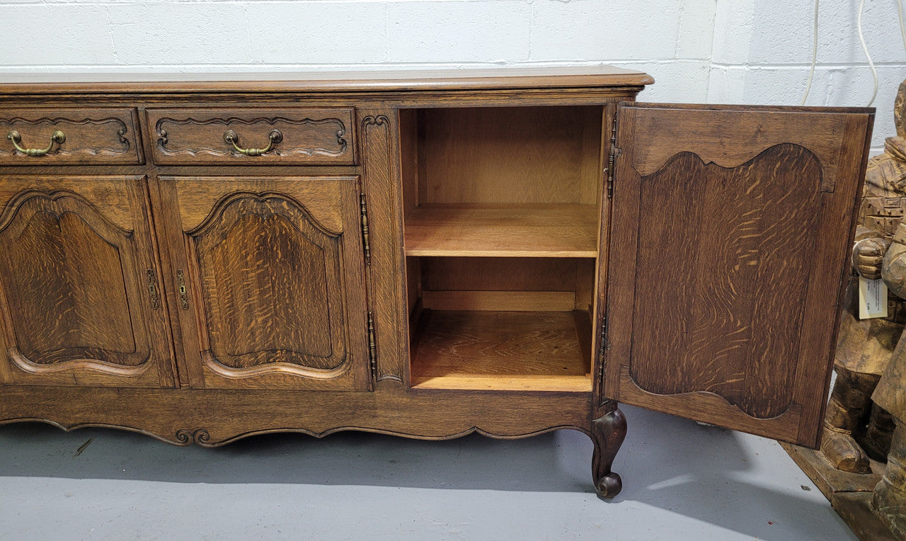 Late 19th Century French carved Oak Louis XV style four drawer sideboard. Plenty of storage space with four cupboards and two drawers. It is in good original detailed condition with all locks functioning with keys.