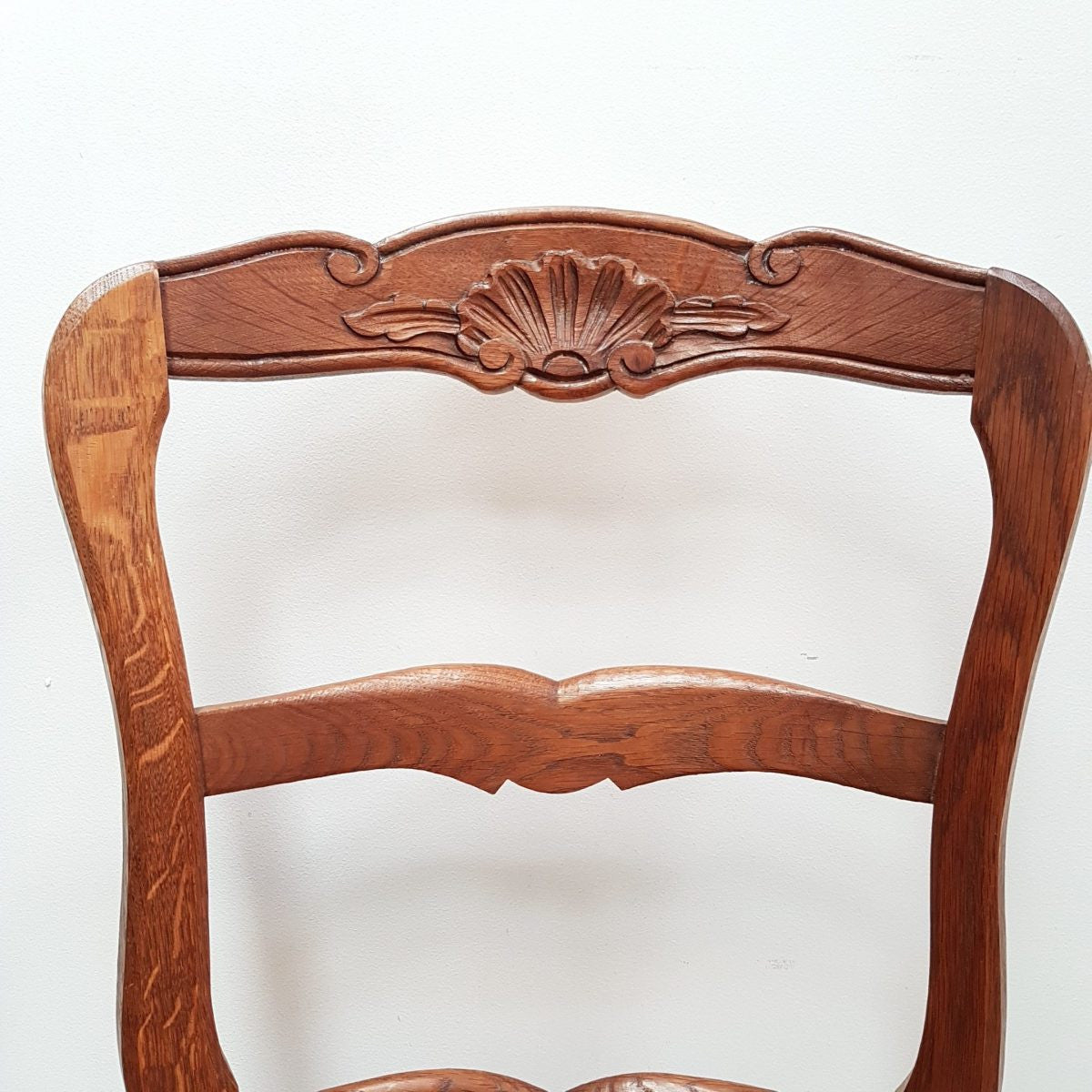A set of six French Louis XV style, ladder back oak chairs. With finely carved detail and rush seat. In great original condition. Chairs are comfortable and sturdy for everyday use.