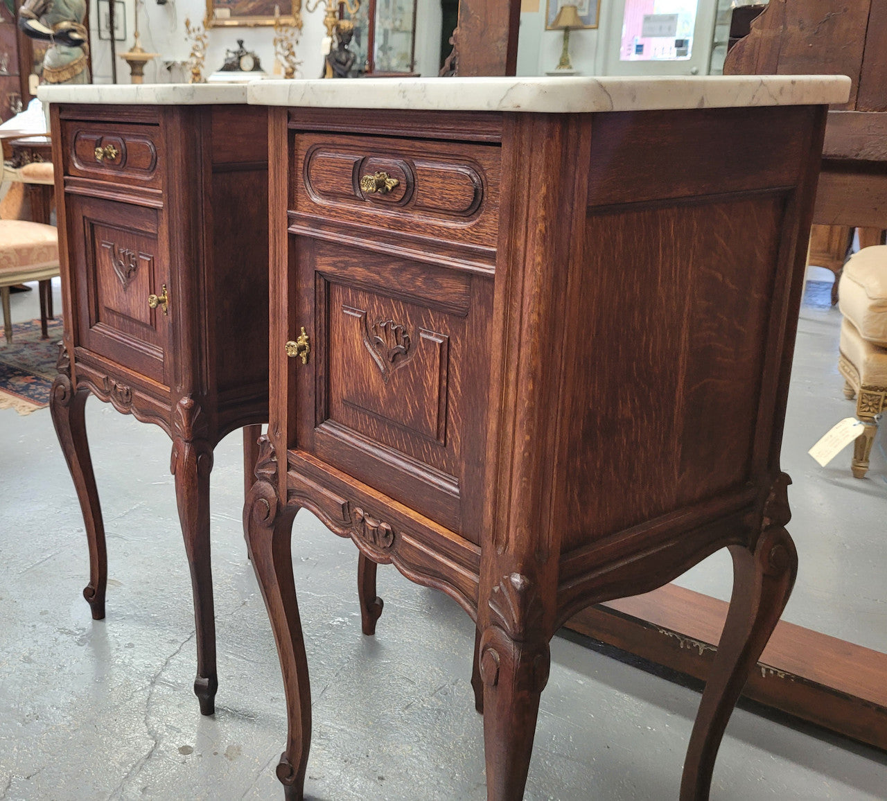 Pair French oak Louis XV style white carrera marble top bedside cabinets. Consisting of one drawer and one cupboard each on elegant legs. Circa: 1900's
