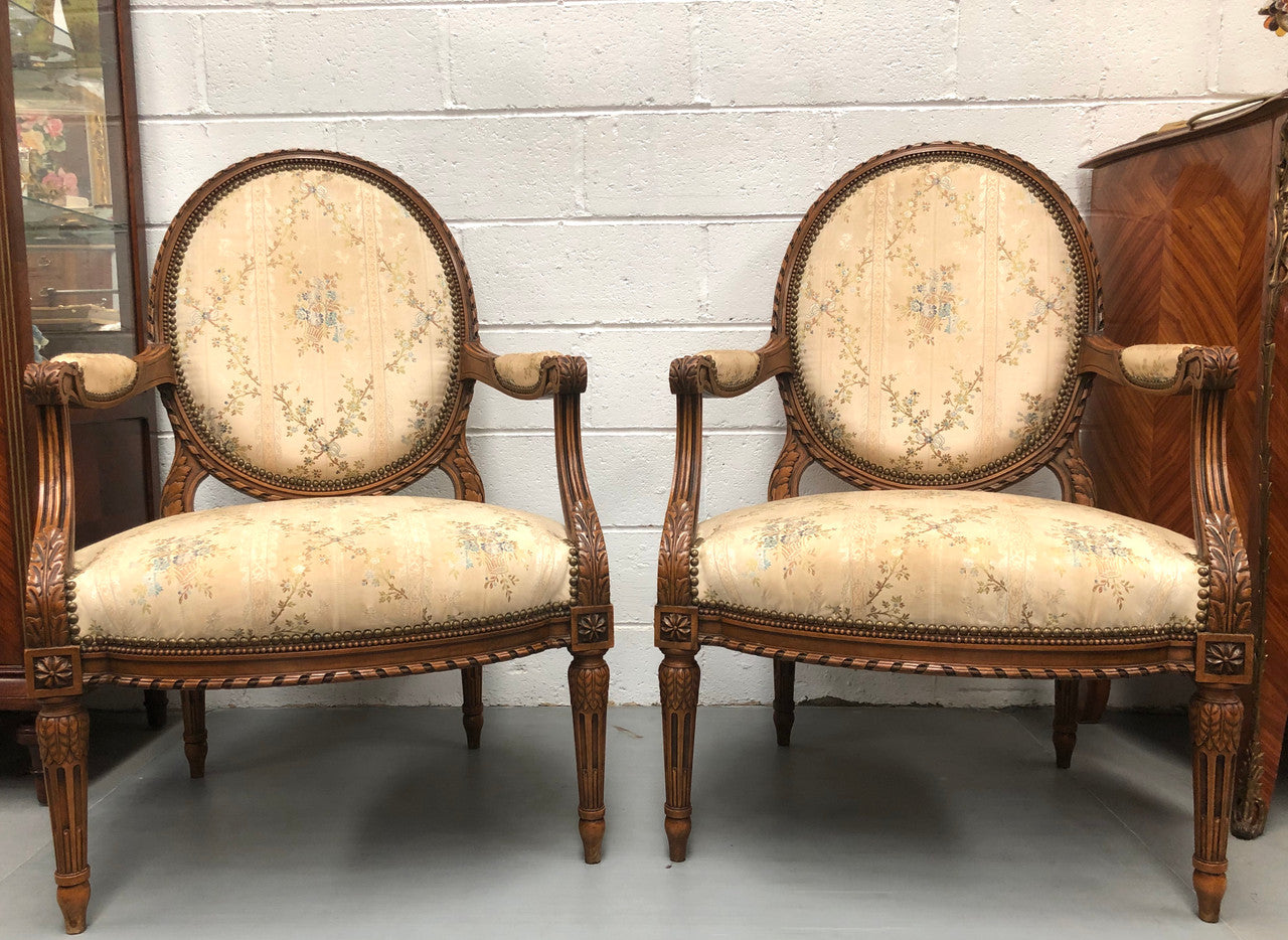 Pair of Antique French Louis XVI style carved Walnut fauteuils in restored condition. The Tapestry upholstery is in good condition some marks and wear but usable.