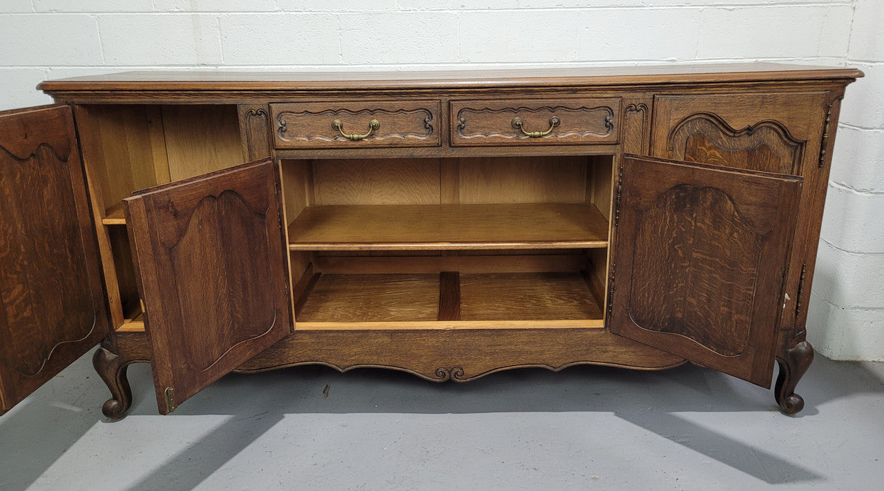 Late 19th Century French carved Oak Louis XV style four drawer sideboard. Plenty of storage space with four cupboards and two drawers. It is in good original detailed condition with all locks functioning with keys.