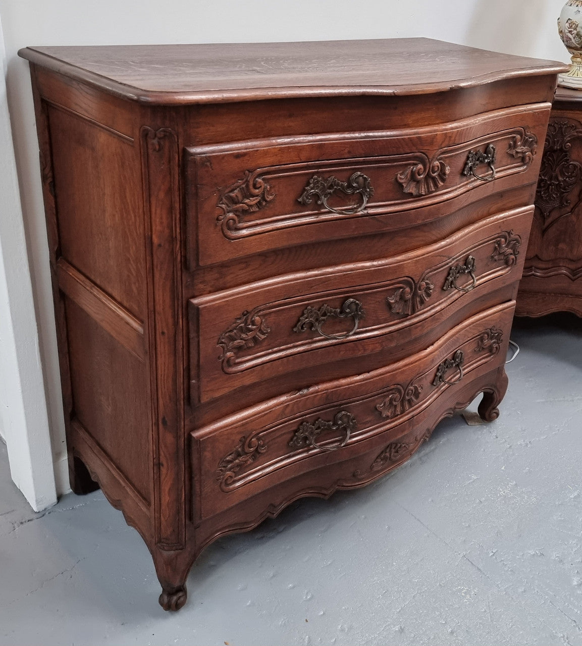 Antique French beautifully carved dark Oak commode with three drawers and ornate handles. It is in good original detailed condition.