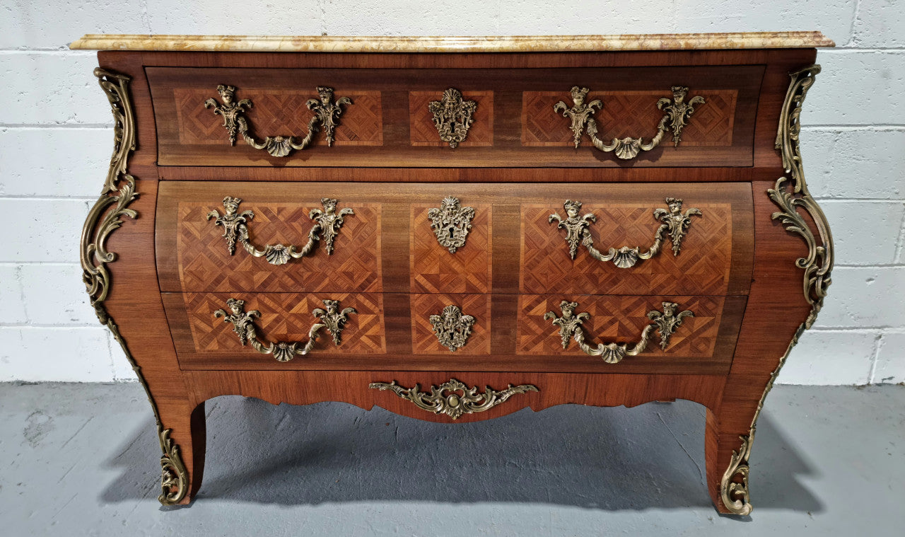 A beautifully inlaid parquetry three drawer commode with a lovely marble top, and decorative ormolu mounts. In good original detailed condition. Circa 1930