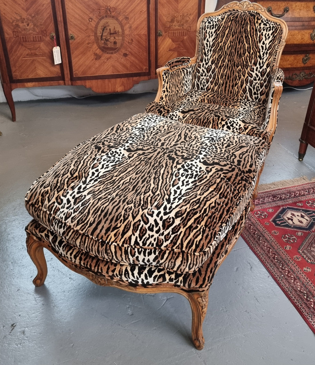 A French Louis XV style armchair with leopard print upholstery and with matched footstool. Fabric is in good original used condition. Please view photos as they help form part of the description.
