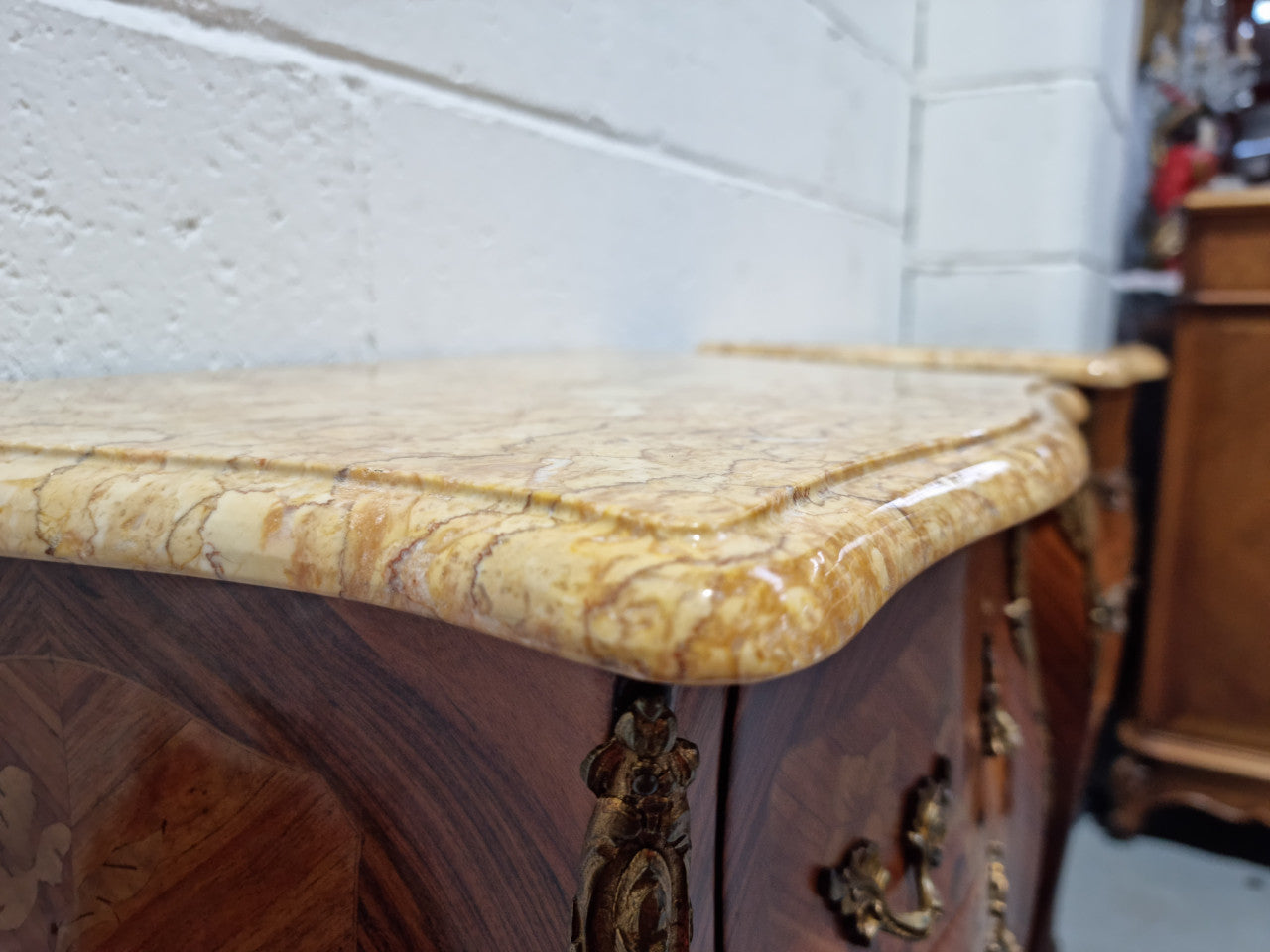 Pair of French bombe shaped commode style marquetry inlaid Kingwood bedside cabinets with marble tops and gilt brass mounts. Circa 1930 in good original detailed condition.