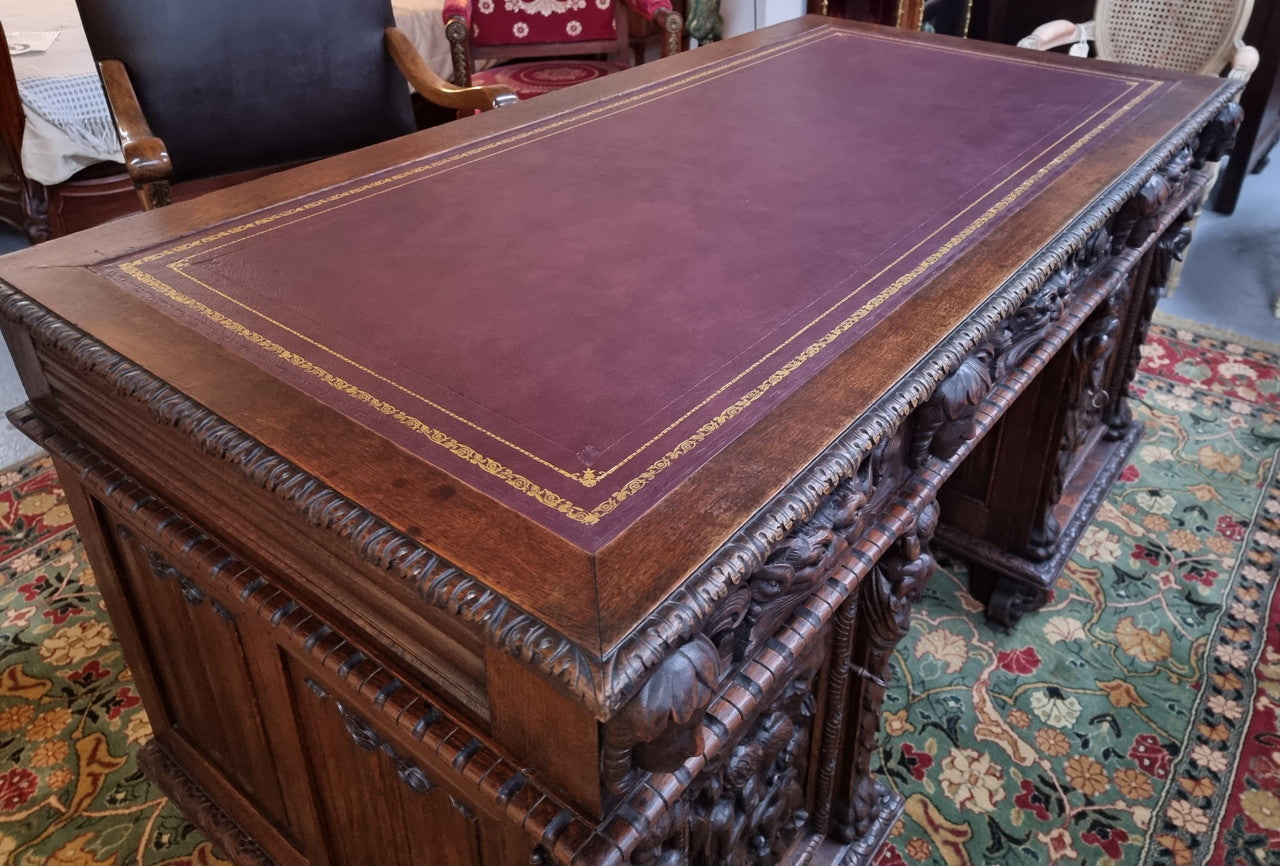 Beautifully carved French Oak early 19th century pedestal desk with 3 drawers, two cupboards and a secret cupboard on the side. There is also a lovely burgundy tooled leather top. In good original detailed condition.