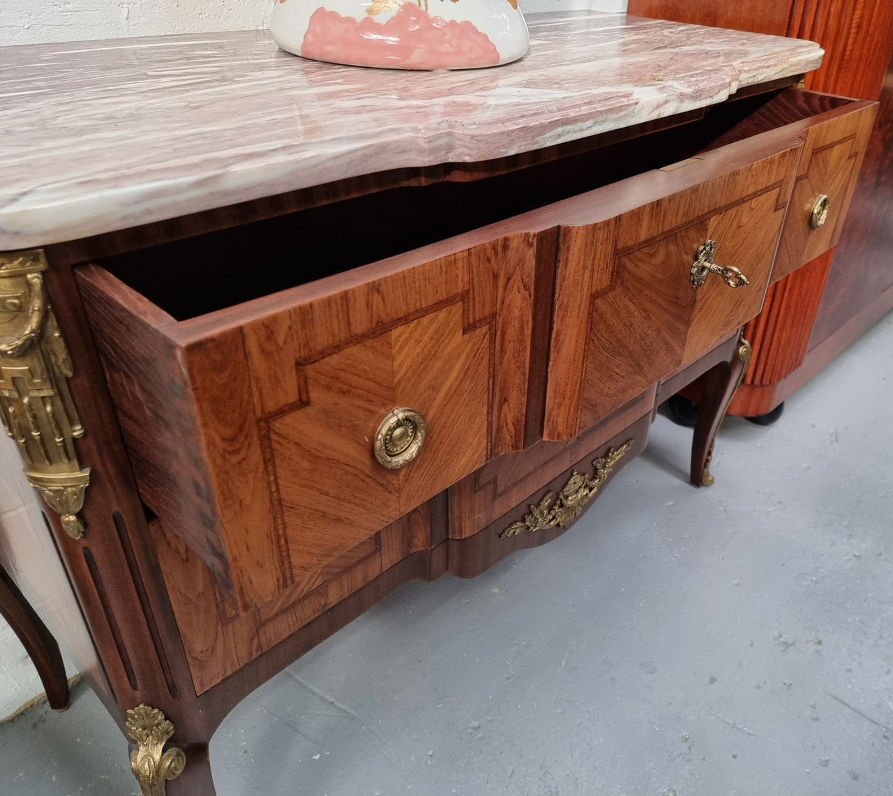 A stunning French transitional Louis XV and Louis XVI style commode. It has beautiful walnut inlay and a fabulous marble top. Comes with two drawers and fitted with gilt brass mounts. it is In very good original condition.