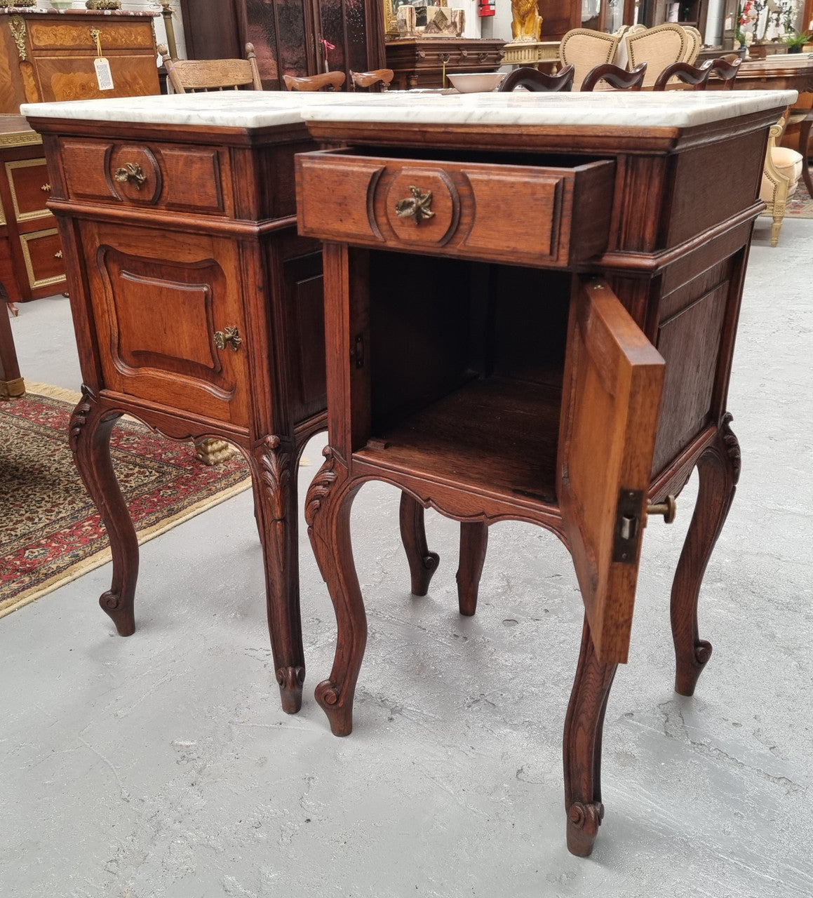 Elegant French Louis XV style pair of carved Oak white marble top bedsides. They are in good original condition and they have been detailed to a high standard. They have been sourced from France.