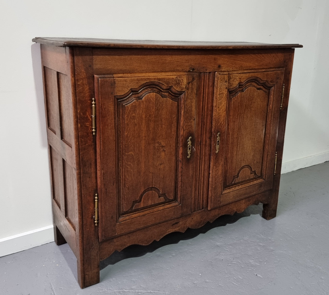 A charming French Oak early 18th Century two door sideboard. Plenty of storage space with two fixed shelves either side. It is in good original detailed condition for its age and comes with a working key and working locks.