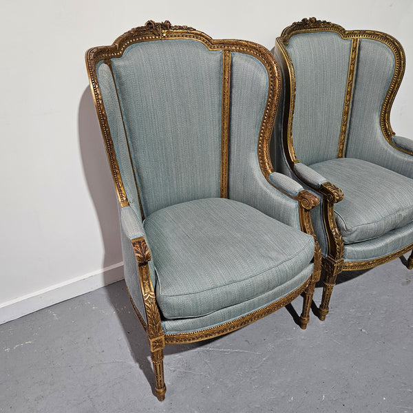 Lovely pair of Louis 16th style gilt & upholstered wingback bergeres with two comfortable cushions. These chairs are in good original condition. Please view photos as they form part of the description.