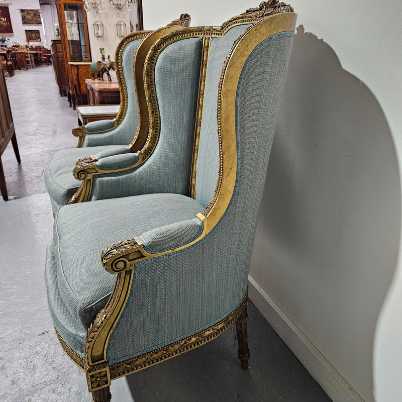 Lovely pair of Louis 16th style gilt & upholstered wingback bergeres with two comfortable cushions. These chairs are in good original condition. Please view photos as they form part of the description.