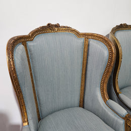 Lovely pair of Louis 16th style gilt & upholstered wingback bergeres with two comfortable cushions. These chairs are in good original condition. Please view photos as they form part of the description.