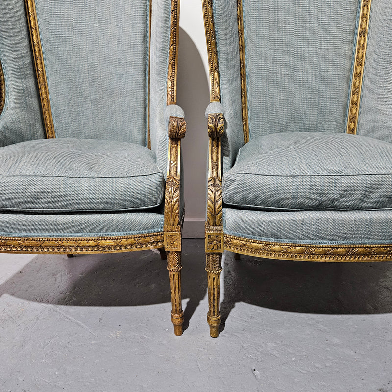 Lovely pair of Louis 16th style gilt & upholstered wingback bergeres with two comfortable cushions. These chairs are in good original condition. Please view photos as they form part of the description.