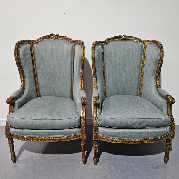 Lovely pair of Louis 16th style gilt & upholstered wingback bergeres with two comfortable cushions. These chairs are in good original condition. Please view photos as they form part of the description.