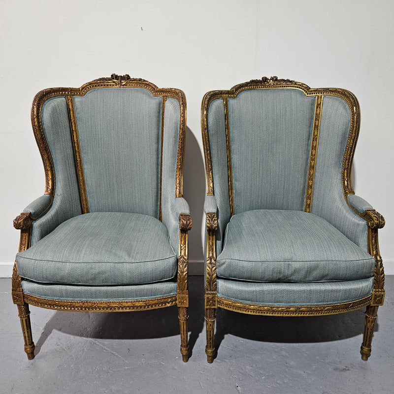 Lovely pair of Louis 16th style gilt & upholstered wingback bergeres with two comfortable cushions. These chairs are in good original condition. Please view photos as they form part of the description.