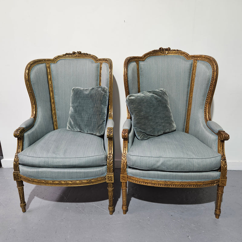 Lovely pair of Louis 16th style gilt & upholstered wingback bergeres with two comfortable cushions. These chairs are in good original condition. Please view photos as they form part of the description.