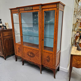 Elegant three door Louis XV transitional style vitrine with decorative bronze mounts. This unit has two glass shelves and one wooden shelf providing plenty of storage. It is in great original detailed condition. Please see the photos as they form part of the description. 