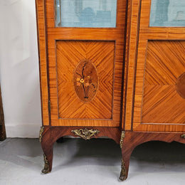 Elegant three door Louis XV transitional style vitrine with decorative bronze mounts. This unit has two glass shelves and one wooden shelf providing plenty of storage. It is in great original detailed condition. Please see the photos as they form part of the description. 