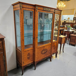 Elegant three door Louis XV transitional style vitrine with decorative bronze mounts. This unit has two glass shelves and one wooden shelf providing plenty of storage. It is in great original detailed condition. Please see the photos as they form part of the description. 