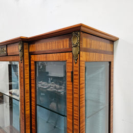 Elegant three door Louis XV transitional style vitrine with decorative bronze mounts. This unit has two glass shelves and one wooden shelf providing plenty of storage. It is in great original detailed condition. Please see the photos as they form part of the description. 