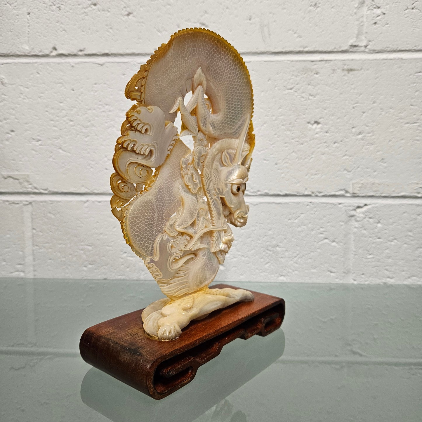 Stunning Dragon Carving on Mother of Pearl.  Mounted on Wooden Stand.  Please see photos as they form part of the description.
