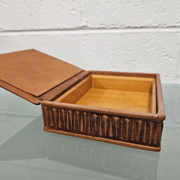 Interesting embossed leather and wood attached lid trinket box. In good original condition. Please see photos as they form part of the description.