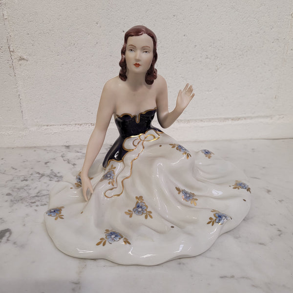 This Royal Dux Bohemia seated figurine of a lady is a beautiful and sophisticated piece. She is wearing a cobalt blue and white dress, and is in good original condition; please review the accompanying photos for more details.