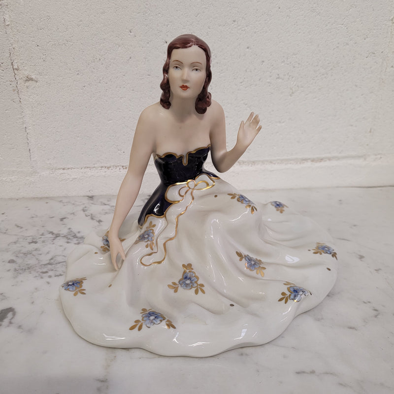 This Royal Dux Bohemia seated figurine of a lady is a beautiful and sophisticated piece. She is wearing a cobalt blue and white dress, and is in good original condition; please review the accompanying photos for more details.