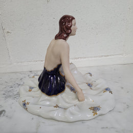 This Royal Dux Bohemia seated figurine of a lady is a beautiful and sophisticated piece. She is wearing a cobalt blue and white dress, and is in good original condition; please review the accompanying photos for more details.