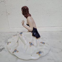 This Royal Dux Bohemia seated figurine of a lady is a beautiful and sophisticated piece. She is wearing a cobalt blue and white dress, and is in good original condition; please review the accompanying photos for more details.
