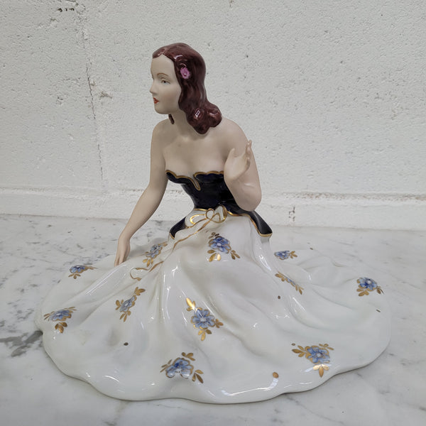 This Royal Dux Bohemia seated figurine of a lady is a beautiful and sophisticated piece. She is wearing a cobalt blue and white dress, and is in good original condition; please review the accompanying photos for more details.
