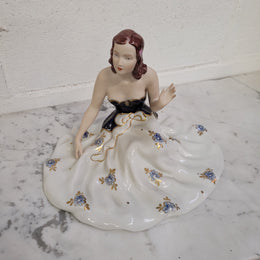 This Royal Dux Bohemia seated figurine of a lady is a beautiful and sophisticated piece. She is wearing a cobalt blue and white dress, and is in good original condition; please review the accompanying photos for more details.