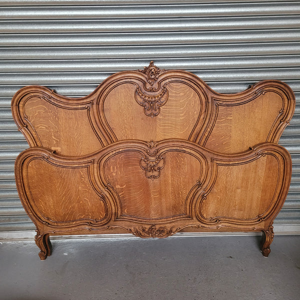 Beautifully carved French Oak Louis XV style queen size bed. It comes with beautiful carved side rails and custom made slats ready for your mattress. Sourced from France it is in good original detailed condition.
