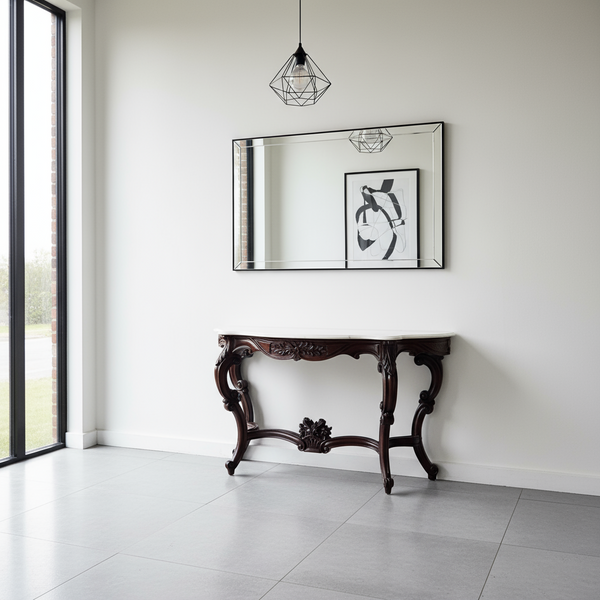 Decorative console table in a room with a large mirror and framed picture on the wall.