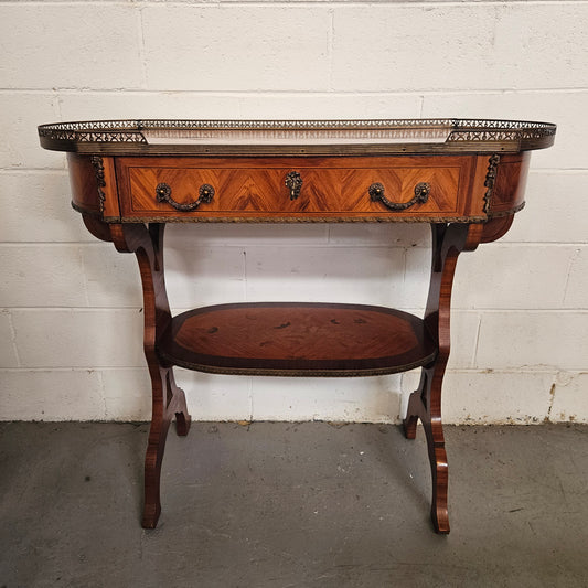 Charming mahogany & walnut marquetry inlaid 2 shelf sofa table. It has 1 drawer and a gallery to the top shelf with further ormolu trims. Sourced from France. In good condition commensurate with age.