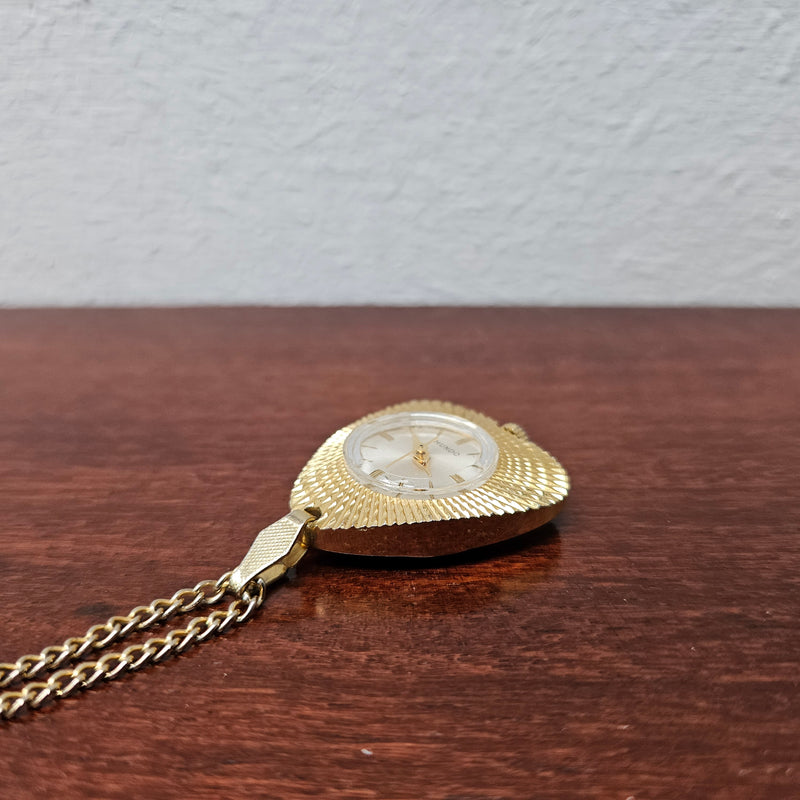 Vintage Gold coloured "Mundo" Pendant Watch. Triangle Shape with round watch face and in working condition.