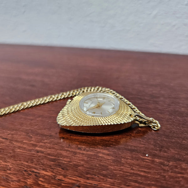 Vintage Gold coloured "Mundo" Pendant Watch. Triangle Shape with round watch face and in working condition.