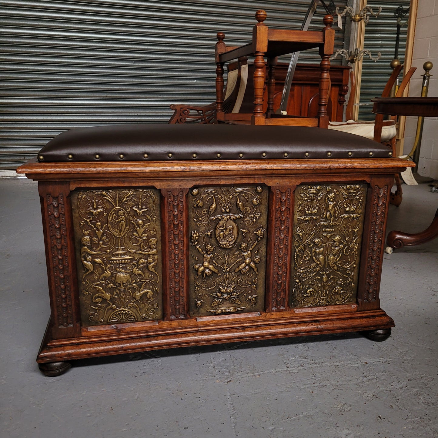 Antique French Oak coffer featuring decorative brass panels and a faux leather top. Brass panels are highly decorative featuring cherubs&nbsp; and faux leather in good used condition with very small signs of wear