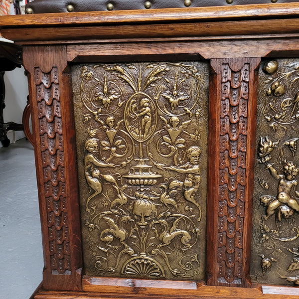Antique French Oak coffer featuring decorative brass panels and a faux leather top. Brass panels are highly decorative featuring cherubs&nbsp; and faux leather in good used condition with very small signs of wear